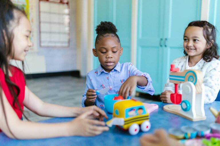 three little girls playing with their toys inside the school