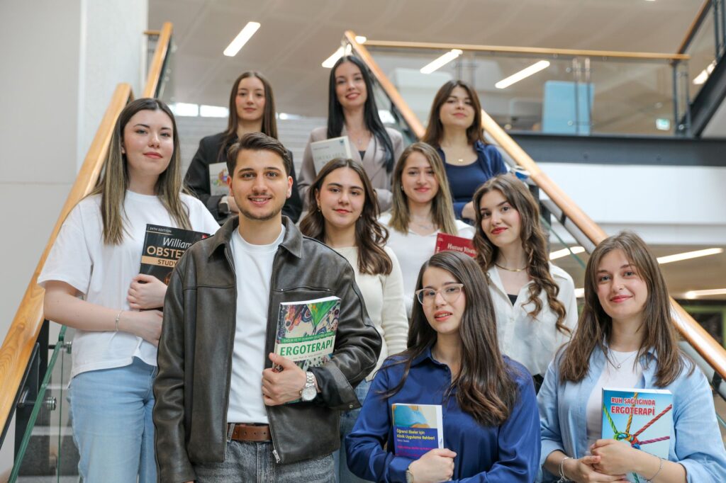 group of students holding books on stairs
